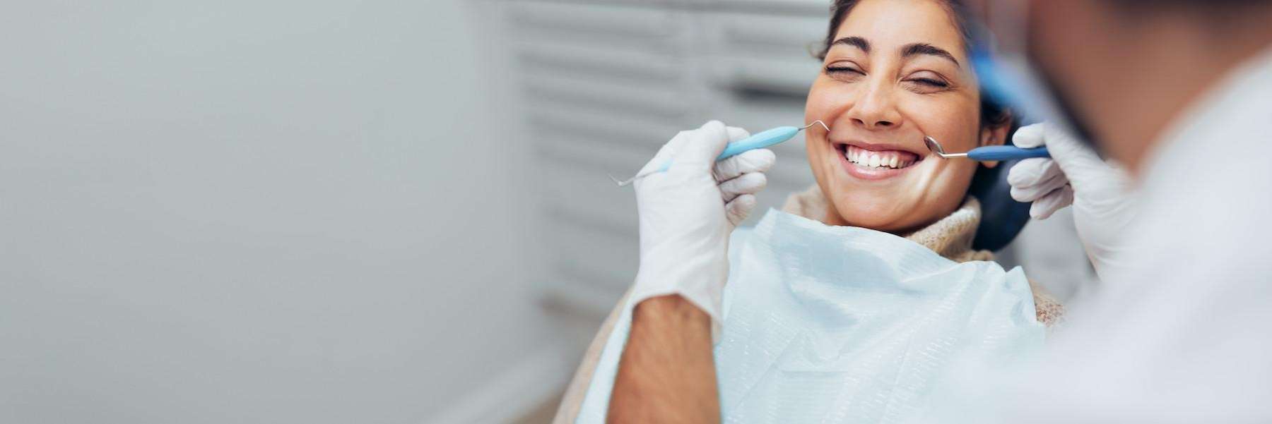 woman sitting in exam chair smiling | dentist medina oh